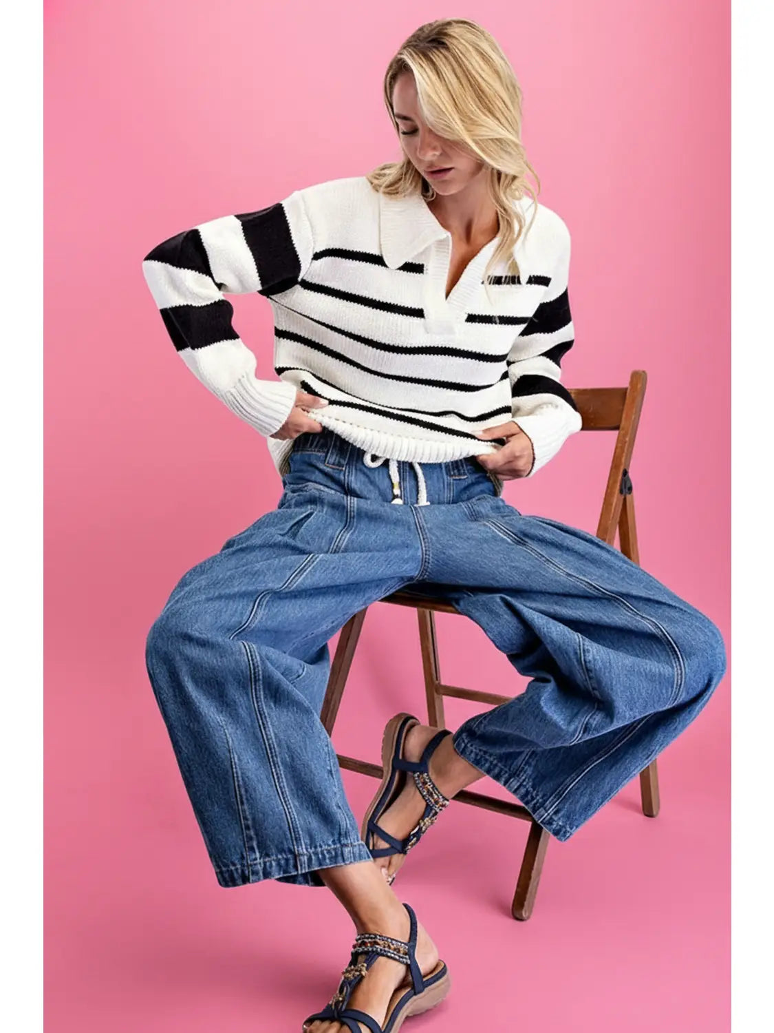 Model sitting wearing The Paloma Barrel Jean — low-slung wide barrel silhouette with corded drawstring waist and seamed paneling, boho-luxe pull-on denim by Cotierra