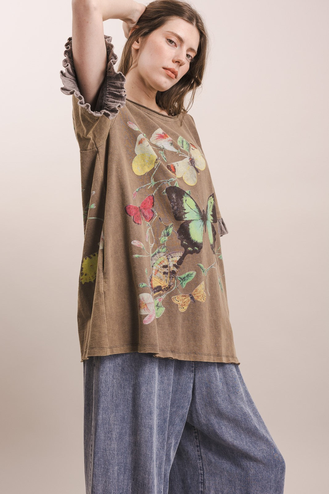 Side view of oversized butterfly print cotton top with ruffle gauze sleeve detail, styled with wide leg denim