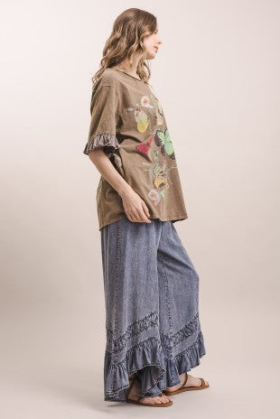 Full length side view of loose fit butterfly graphic top with contrast gauze ruffle hem sleeves and side pocket detail