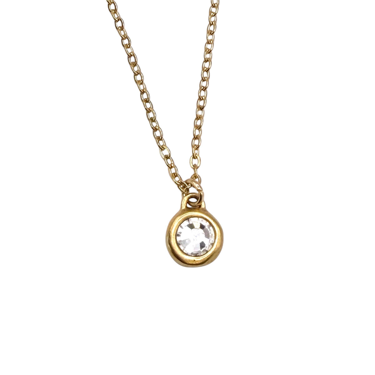 A gold chain necklace with a small round bezel-set clear gemstone pendant, shown against a plain white background.