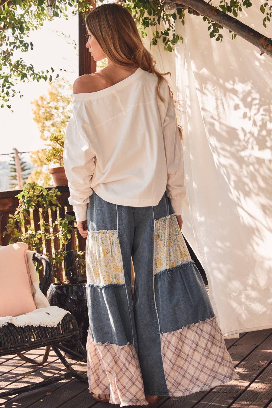 Back view of Plus size mixed fabric patchwork wide leg pants in washed denim with lace inserts, star appliqué, and drawstring waist — boho-luxe women's pants by Spirit & Wind Boutique