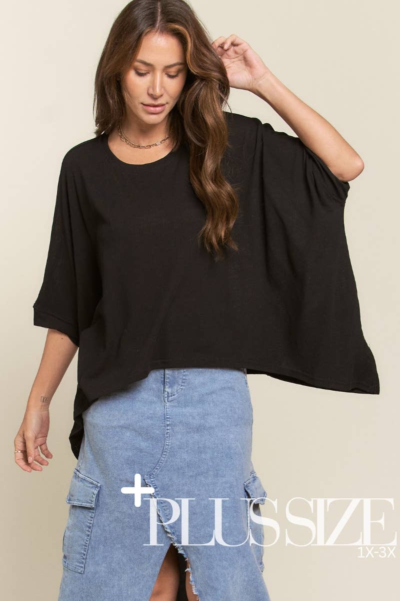 Woman wearing a black oversized top and blue denim skirt with 'Plus Size' text.