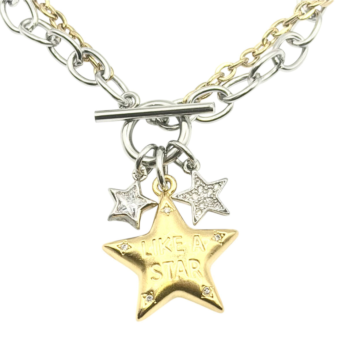 Close up detail of Necklace: Mixed-metal necklace with silver- and gold-tone chains, a toggle clasp, two small silver stars, and a gold star engraved “Like a Star.”

