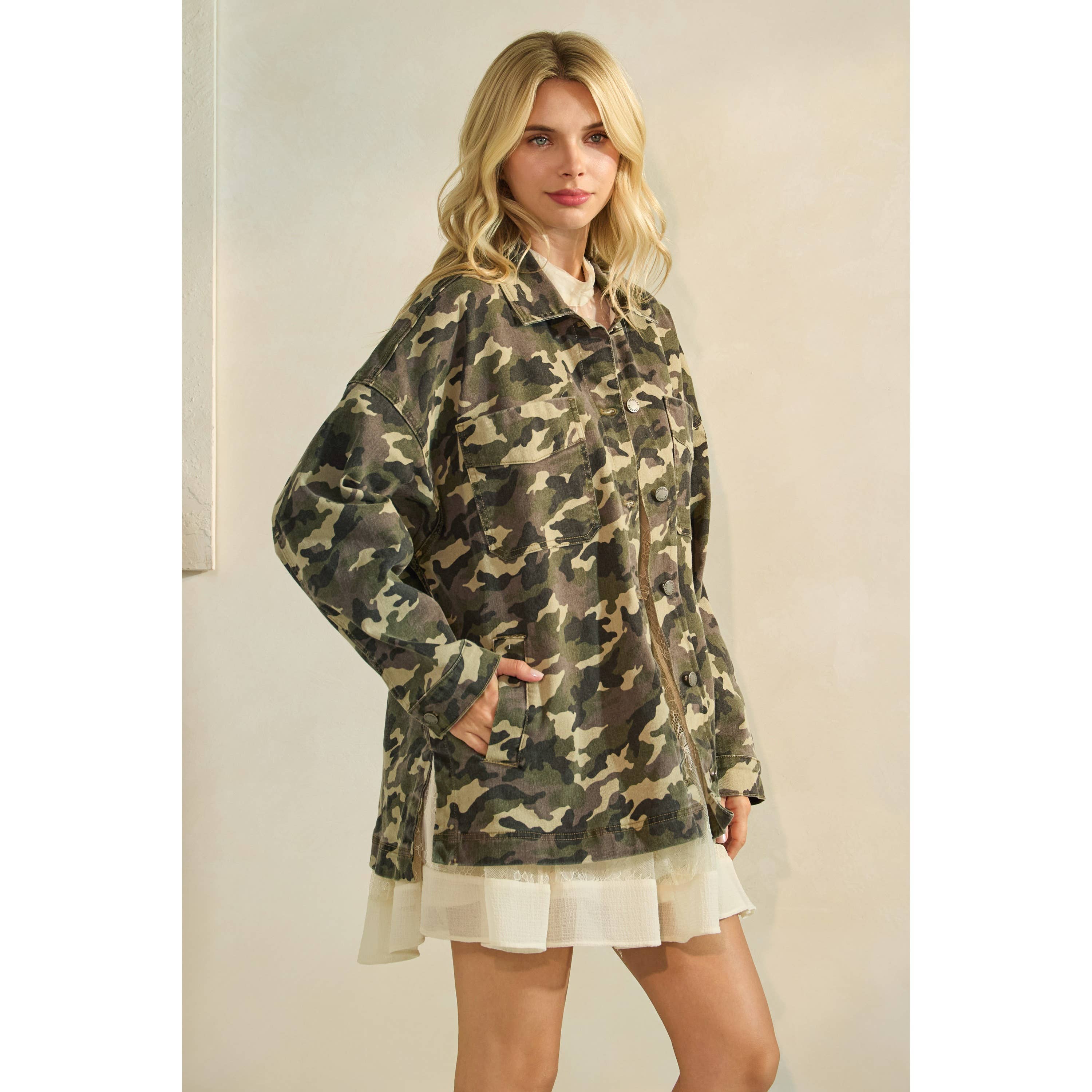 Oversized camouflage print jacket with front pockets and button closure, styled over a white tiered mini dress.