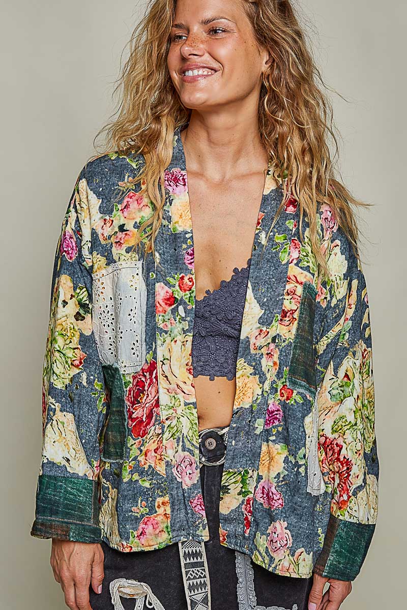 Front view of a woman wearing the Peace in Bloom green floral reversible boho jacket
