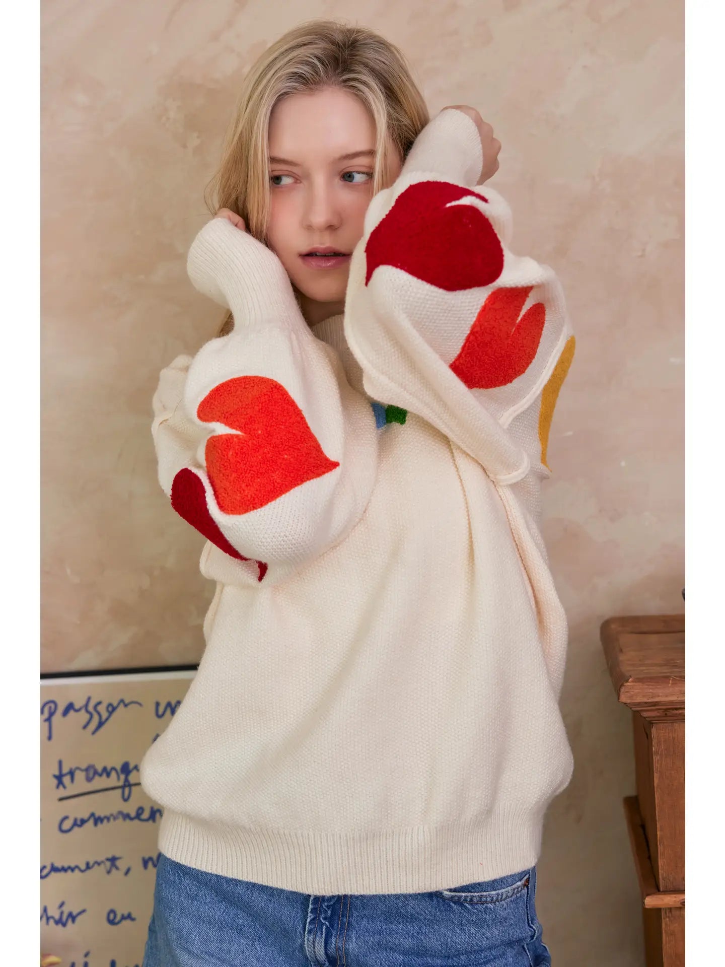 Person wearing a sweater with large white paw prints and red centers.