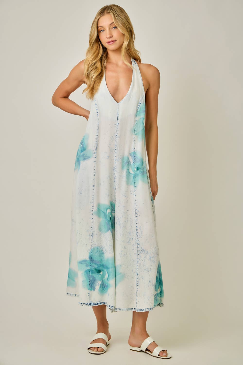 Woman wearing a floral jumpsuit with a plain background