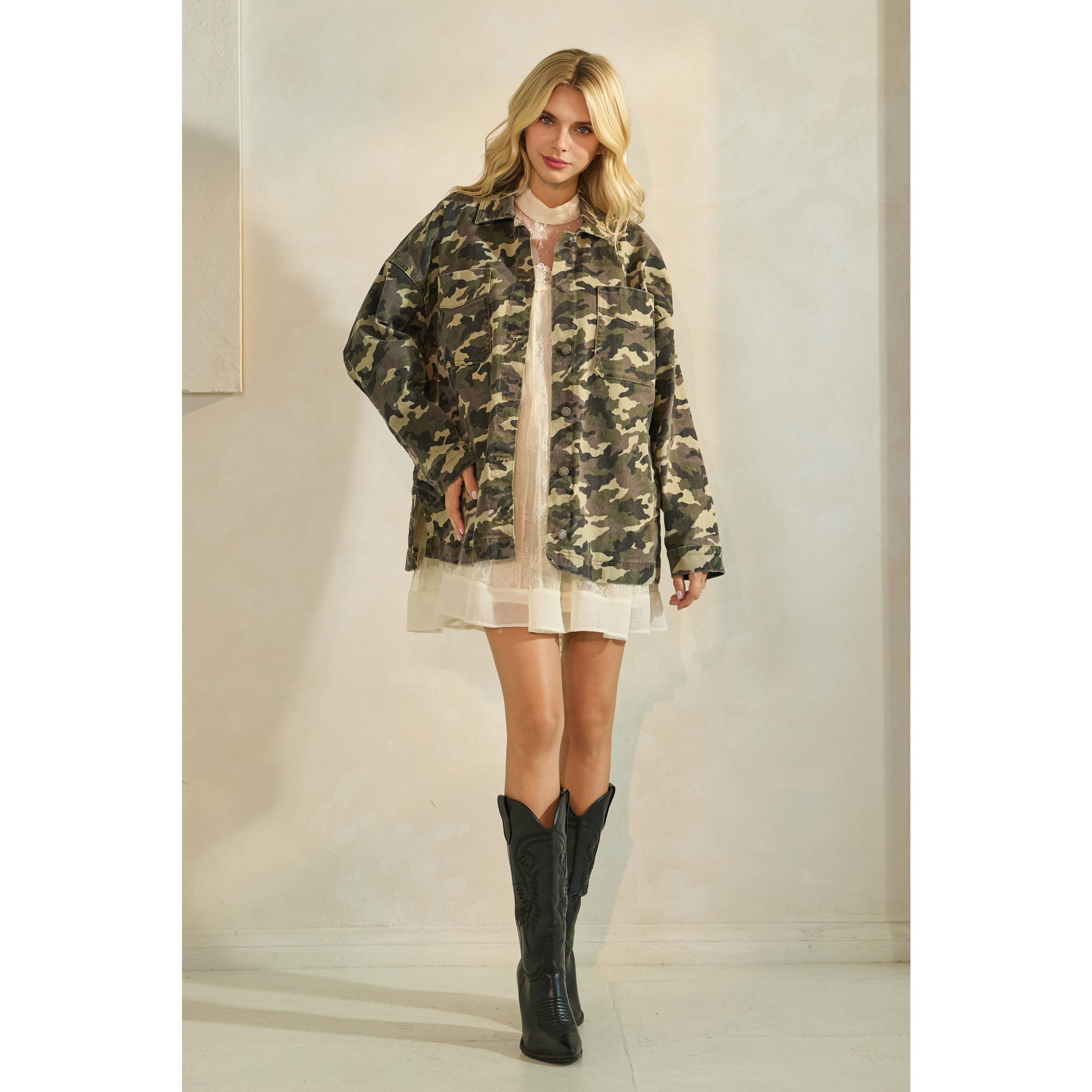 Oversized camouflage print jacket with front pockets and button closure, styled over a white tiered mini dress.
