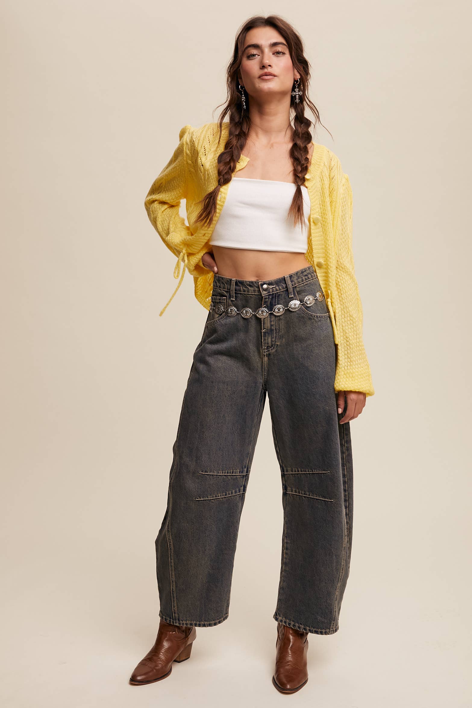 Dark wash wide-leg jeans with relaxed fit, seam detailing across the knees, and a high-rise waist, styled with brown ankle boots.