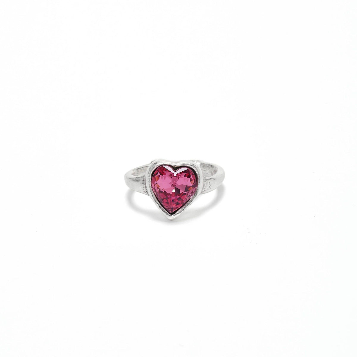 A silver ring featuring a heart-shaped pink gemstone in a bezel setting, centered on a plain white background.