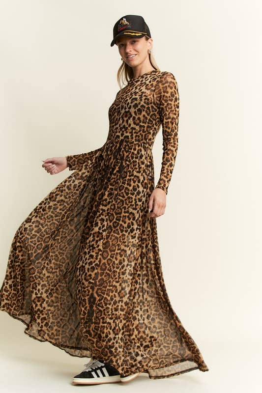 Side view of a leopard-print long-sleeve mesh maxi dress with a sheer, flowy skirt, styled with a black belt, baseball cap, and black-and-white sneakers.