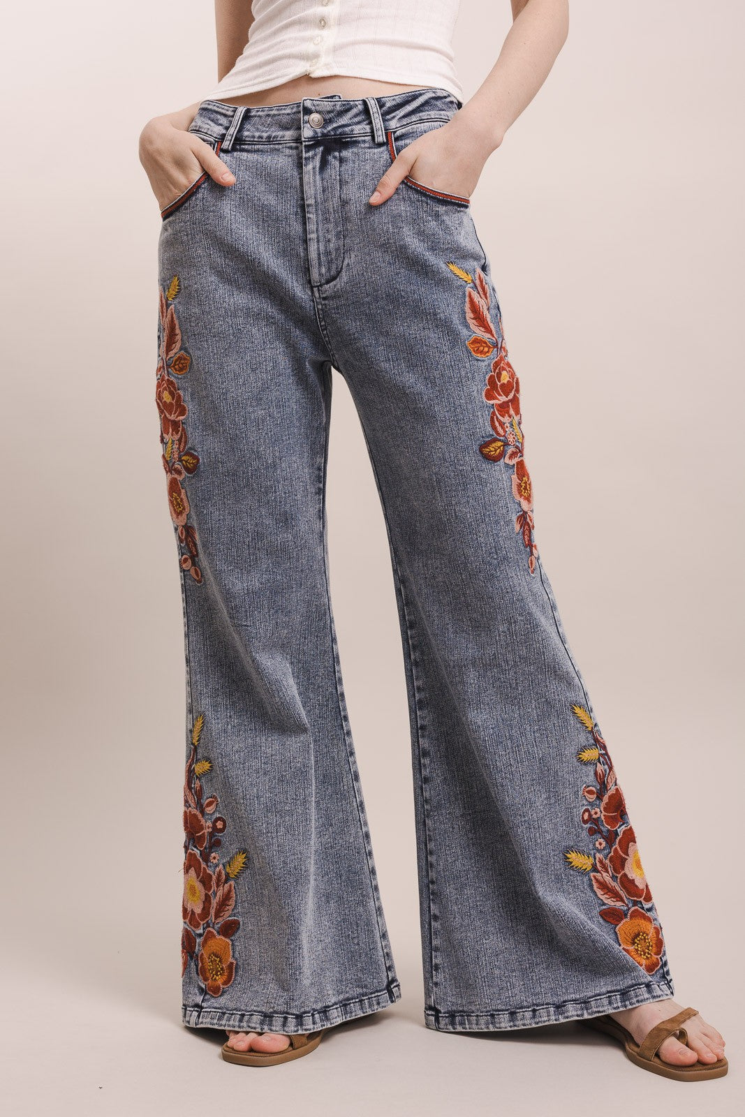 Flared jeans with floral embroidery on a plain background