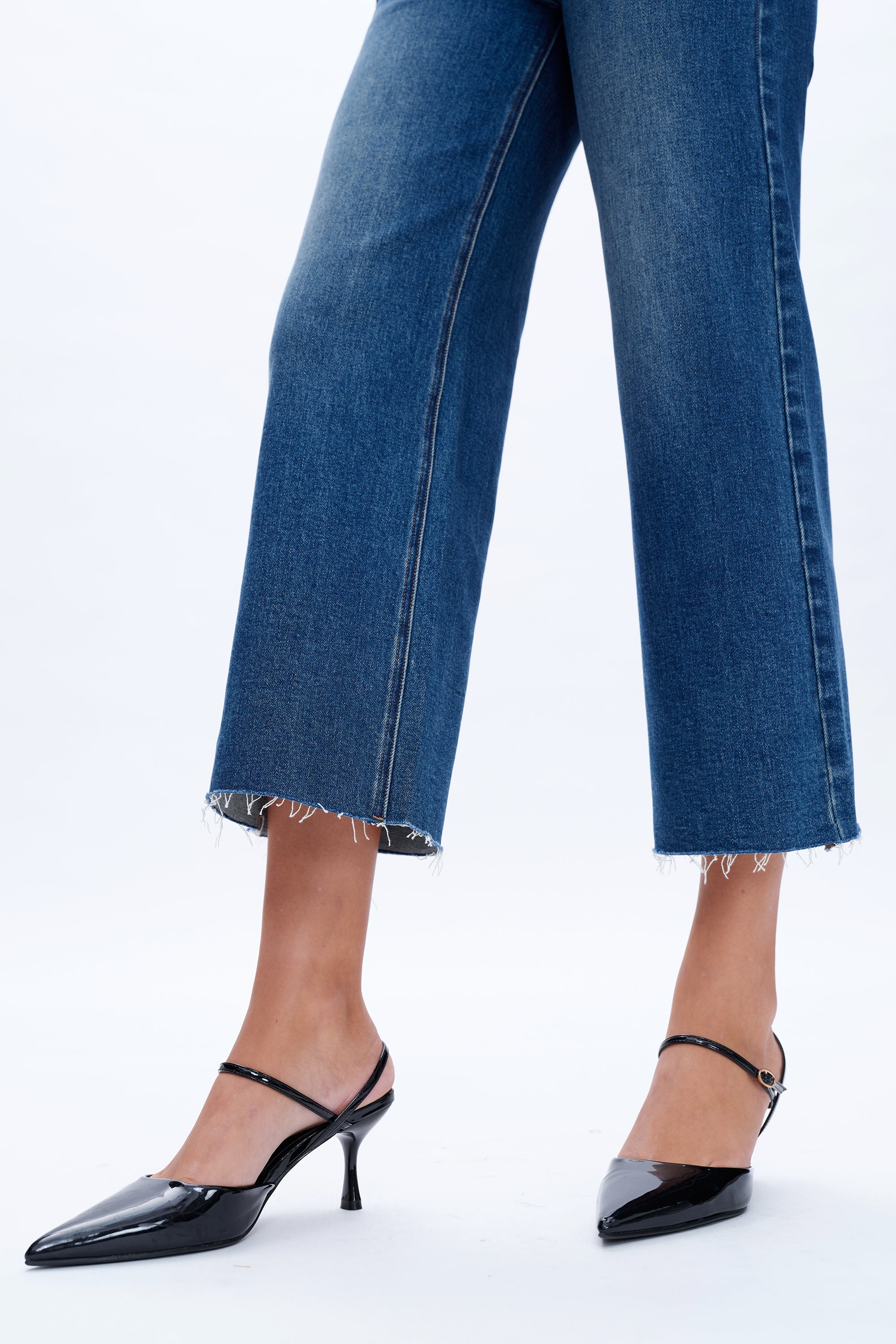 Blue jeans and black high-heeled shoes on a white background