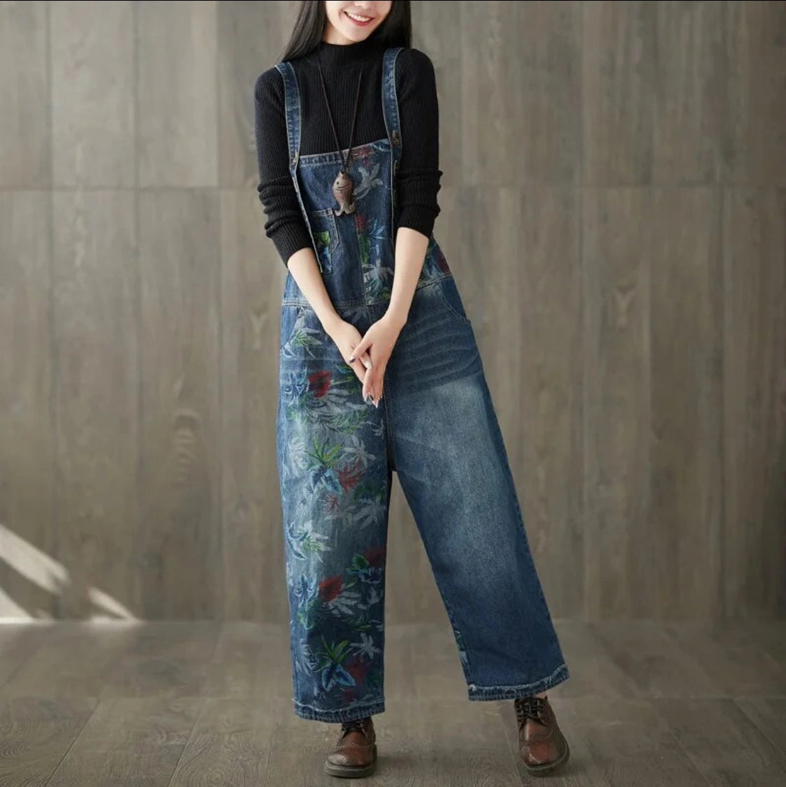 Person wearing blue floral overalls painted against a wooden background