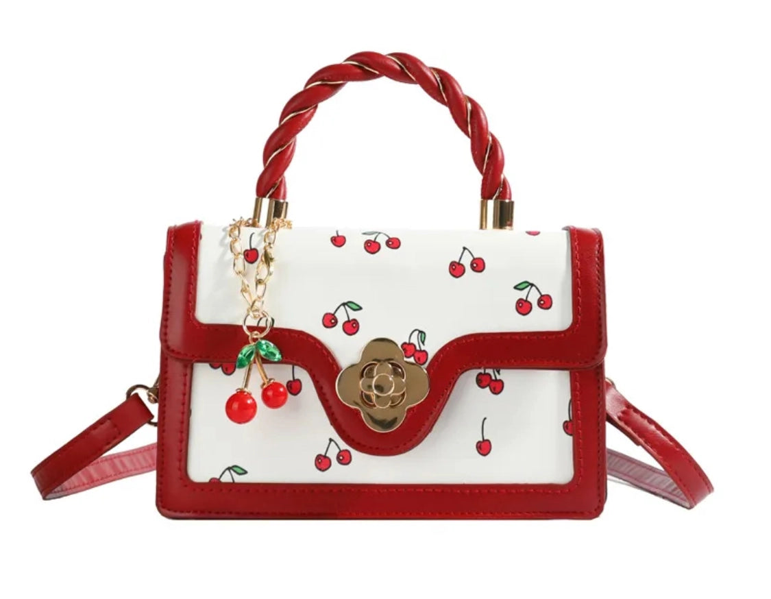 Red and white handbag with cherry design on a white background
